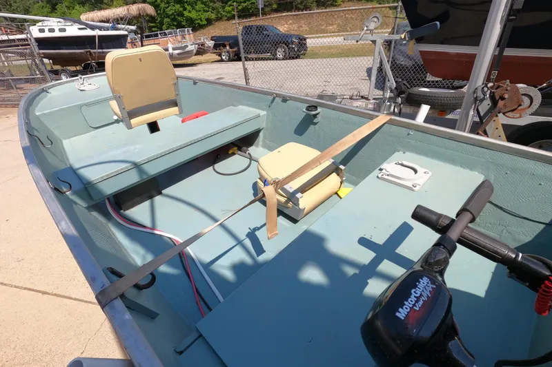 Slide: The Image of 1969 Thundercraft 14 boat interior with seats and motor, parked outdoors. - 10