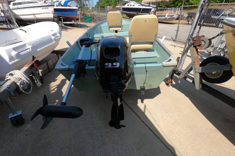 Slide: The Image of 1969 Thundercraft 14 boat with outboard motor, parked on a trailer in a marina. - 4