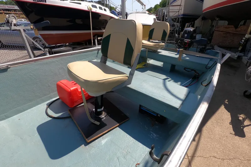 Slide: The Image of 1969 Thundercraft 14 boat interior with seating and equipment, docked outdoors. - 7