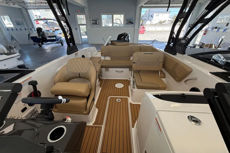 Slide: The Image of 2026 Bayliner VR6 Bowrider OB interior with tan seating and wood-style flooring. - 8