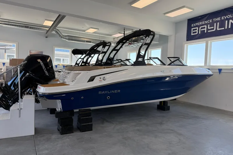 Slide: The Image of 2026 Bayliner VR6 Bowrider OB interior storage compartment with open hatch and seating area. - 9