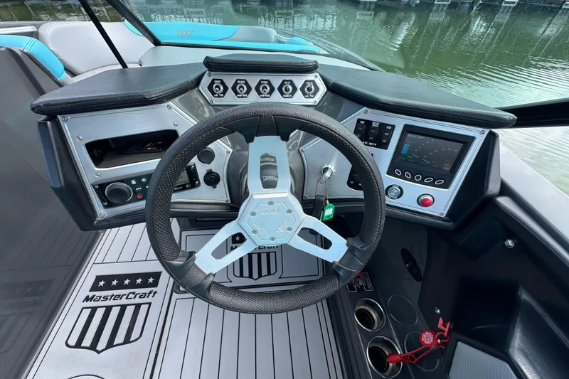 Slide: The Image of 2017 MasterCraft NXT22 boat dashboard with steering wheel and control panels. - 12