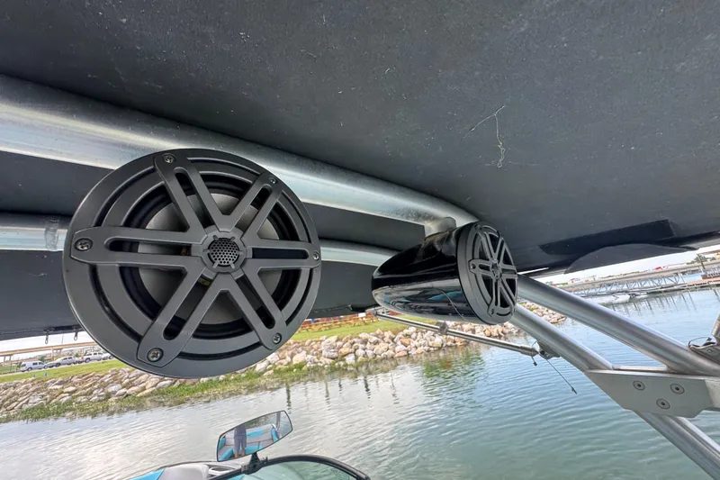 Slide: The Image of 2017 MasterCraft NXT22 boat speakers mounted under canopy by the water. - 20