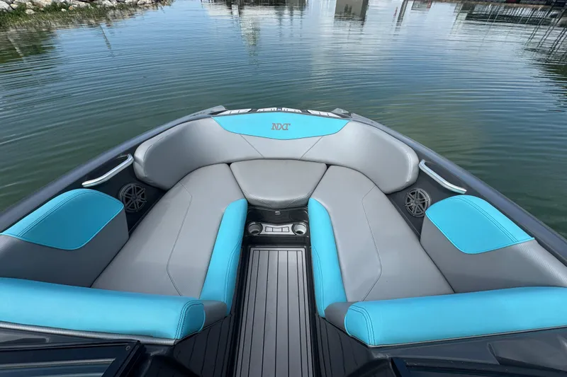 Slide: The Image of 2017 MasterCraft NXT22 boat interior with gray and blue seating on calm water. - 6