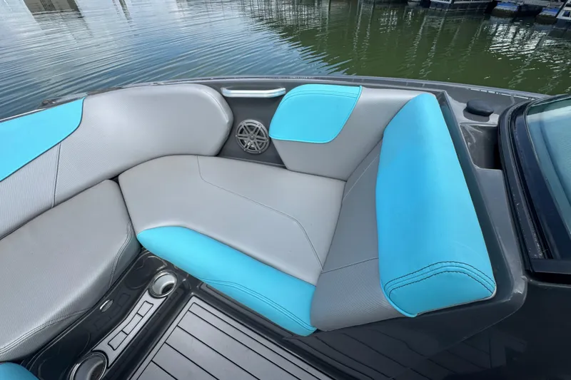 Slide: The Image of 2017 MasterCraft NXT22 boat interior with blue and gray seating by the water. - 8