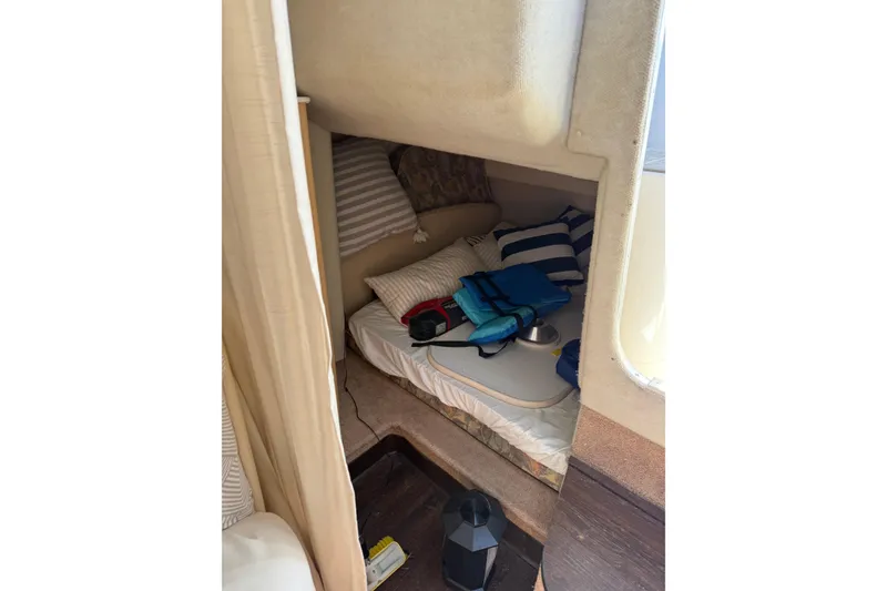 Slide: The Image of Cozy cabin interior of 2000 Bayliner 3055 Ciera Sunbridge with striped pillows and nautical decor. - 8