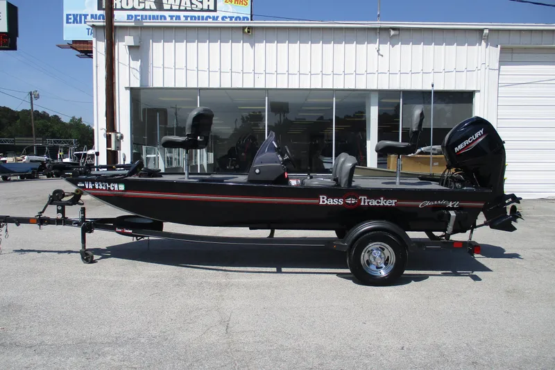 The Image of 2022 Tracker Bass Tracker Classic XL boat on trailer, parked outside a building. - 1