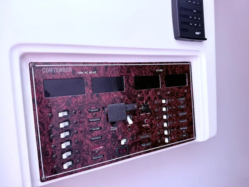 Slide: The Image of Control panel of a 2007 Contender 36 Fish Around boat, featuring switches and displays. - 4