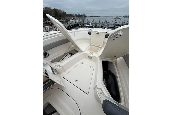 Slide: The Image of 2021 Robalo R242 Explorer boat with open storage compartments, docked by a serene waterfront. - 10