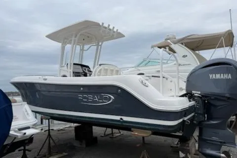 Slide: The Image of 2021 Robalo R242 Explorer boat with Yamaha outboard motor, displayed on stands. - 2