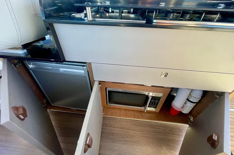 Slide: The Image of Interior of 2020 Beneteau Antares 9 OB showing kitchen with microwave and storage. - 14