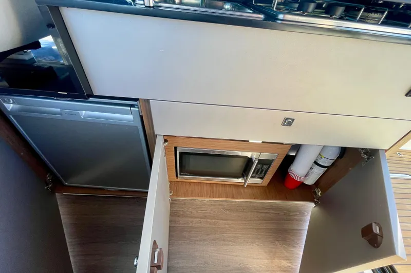 Slide: The Image of Interior of 2020 Beneteau Antares 9 OB showing kitchen appliances and storage. - 15