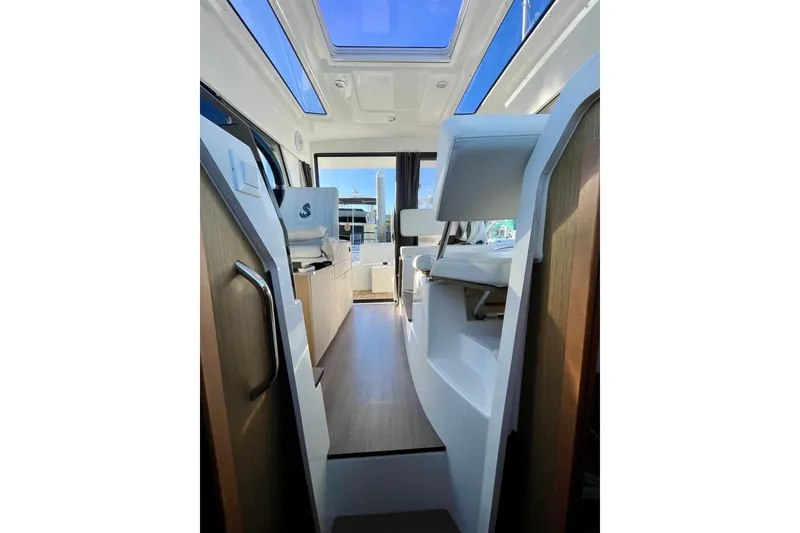 Slide: The Image of Interior view of 2020 Beneteau Antares 9 OB boat, featuring modern design and skylight. - 21