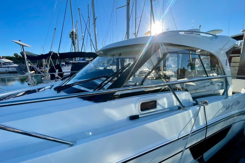 Slide: The Image of 2020 Beneteau Antares 9 OB boat docked in a marina under clear blue sky. - 25