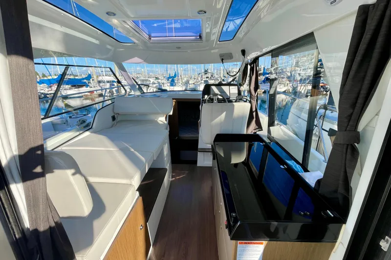 Slide: The Image of Interior of 2020 Beneteau Antares 9 OB boat, featuring seating and panoramic windows. - 8