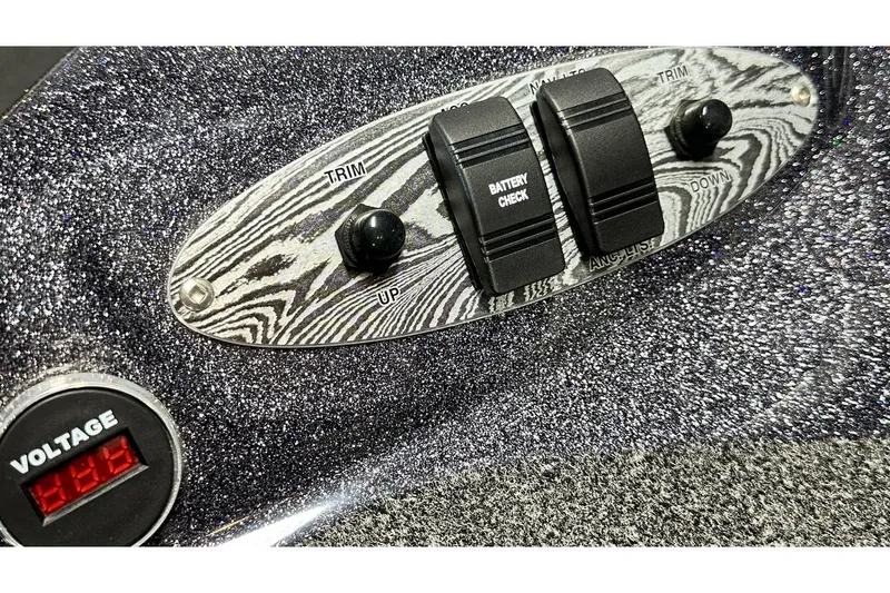 Slide: The Image of Control panel of 2026 Bass Cat Lynx STS boat with trim and battery check switches. - 15