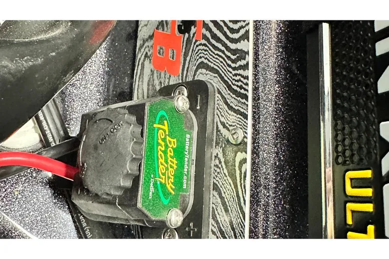 Slide: The Image of Battery Tender connector on 2026 Bass Cat Lynx STS boat, featuring red cable and textured surface. - 18