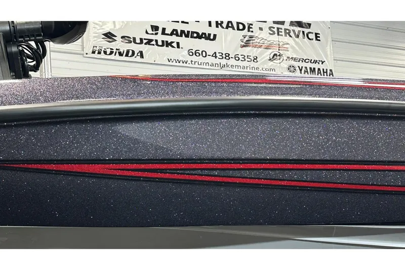Slide: The Image of 2026 Bass Cat Lynx STS boat with glittery finish and red accents, displayed indoors. - 9