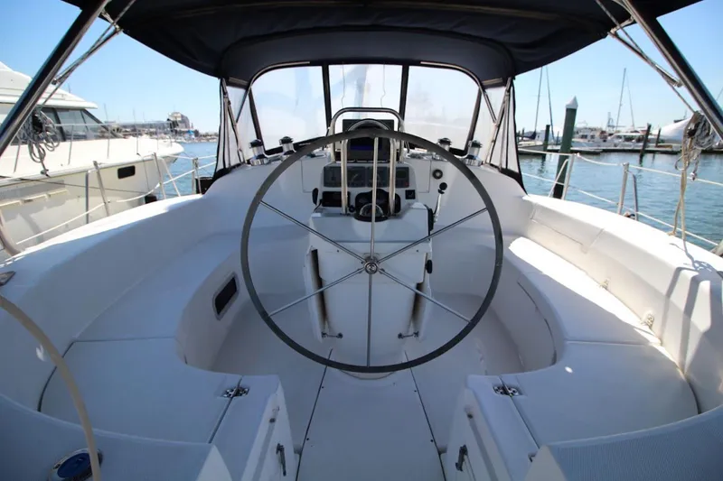 Slide: The Image of Cockpit of 2000 Hunter 410 sailboat with steering wheel and marina view. - 14