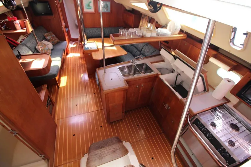Slide: The Image of Interior of a 2000 Hunter 410 sailboat with wood finish and cozy seating area. - 16