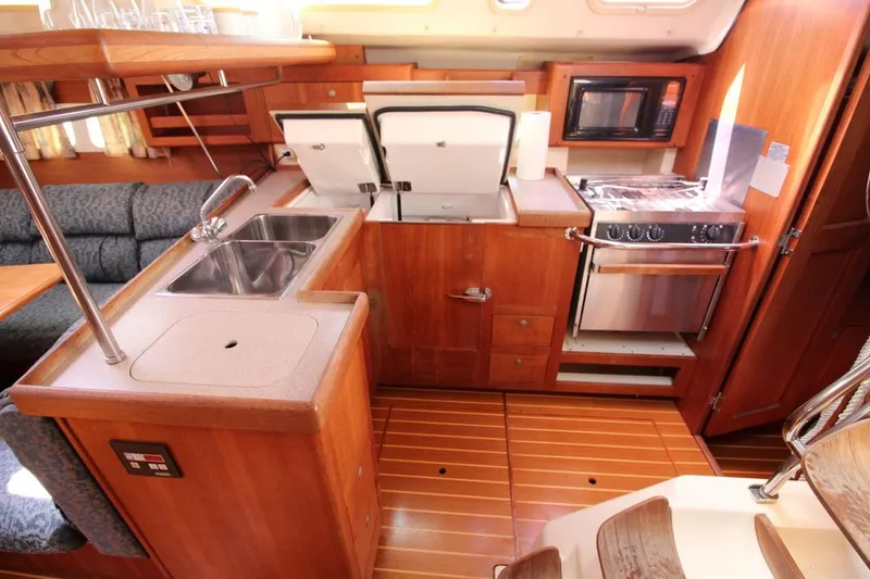 Slide: The Image of Interior of a 2000 Hunter 410 yacht kitchen with wood finish and modern appliances. - 17