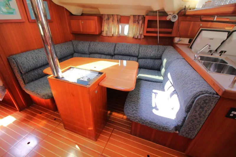 Slide: The Image of Interior of a 2000 Hunter 410 sailboat with cozy seating and wooden finishes. - 18