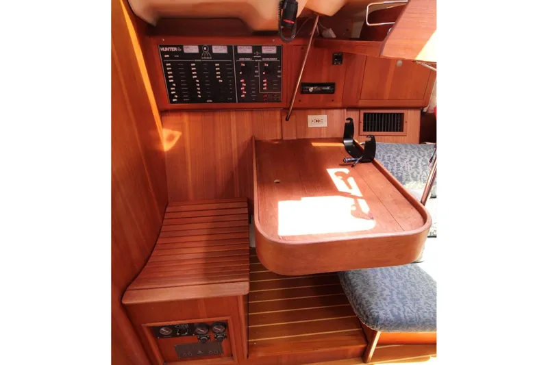 Slide: The Image of Interior of a 2000 Hunter 410 sailboat featuring a wooden navigation station. - 19