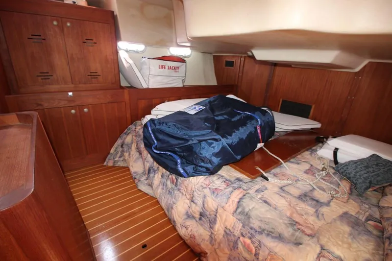 Slide: The Image of Cozy cabin interior of 2000 Hunter 410 sailboat with wooden cabinetry and life jackets. - 25
