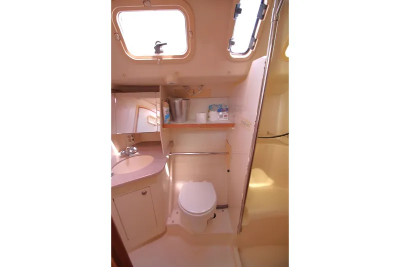 Slide: The Image of Interior of 2000 Hunter 410 yacht bathroom with sink, toilet, and storage shelves. - 26