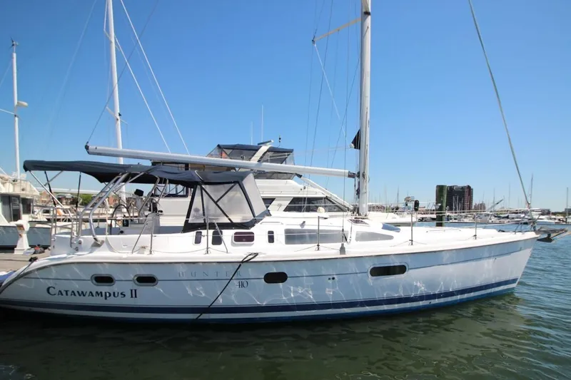 Slide: The Image of Sailboat "Catawampus II," Hunter 410, 2000 model, docked in a marina under clear skies. - 3