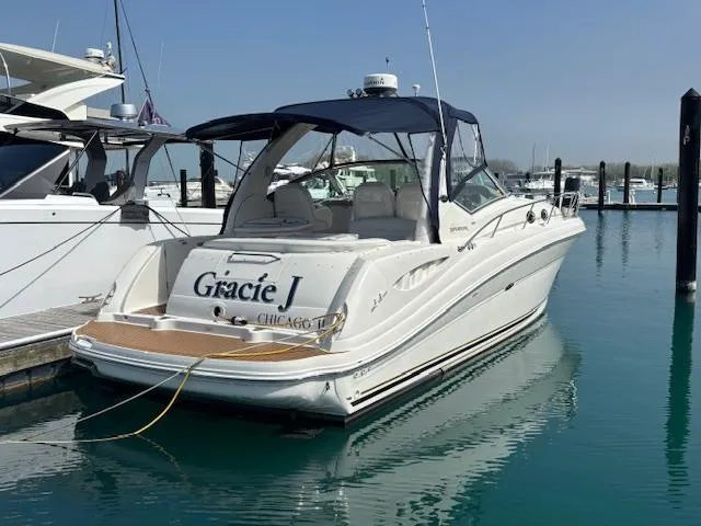 The Image of 2003 Sea Ray 340 Sundancer docked in marina, named "Gracie J," with blue canopy. - 0