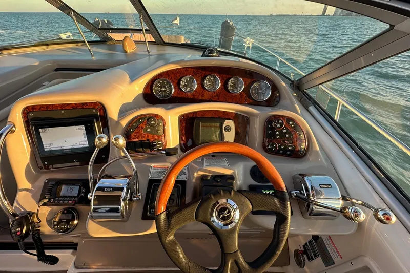 Slide: The Image of Cockpit of 2003 Sea Ray 340 Sundancer with steering wheel and control panel, overlooking ocean. - 27