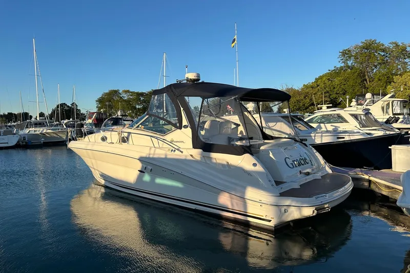 Slide: The Image of 2003 Sea Ray 340 Sundancer yacht docked in a marina under clear blue skies. - 28