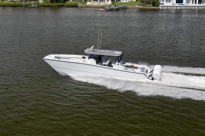 Slide: The Image of 2020 Freeman 42LR boat cruising on a calm river, showcasing sleek design and powerful engines. - 11