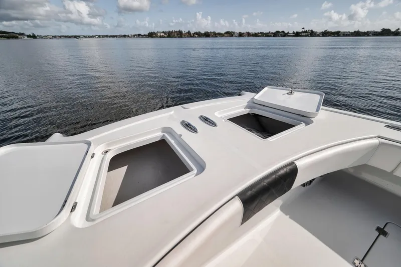 Slide: The Image of Bow view of 2020 Freeman 42LR boat with open storage compartments on calm water. - 13