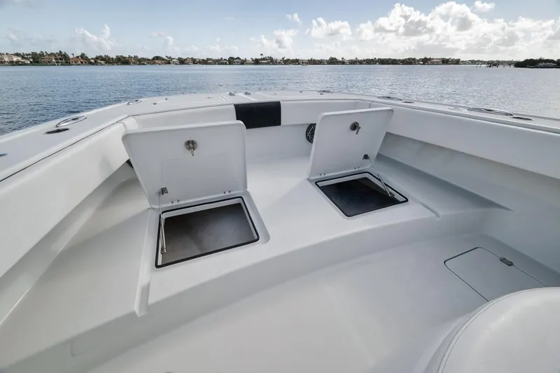 Slide: The Image of 2020 Freeman 42LR boat deck with open storage compartments on calm water. - 15