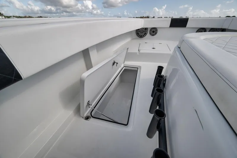 Slide: The Image of 2020 Freeman 42LR boat interior with open storage compartment and rod holders. - 16