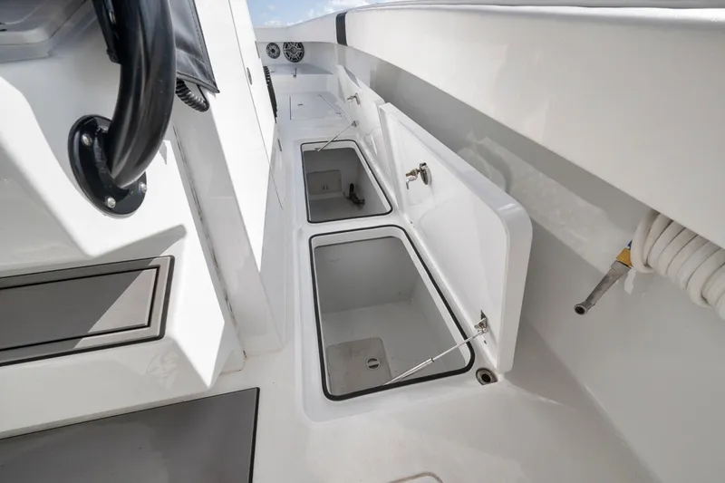 Slide: The Image of Freeman 42LR 2020 boat interior with open storage compartments and steering wheel. - 25