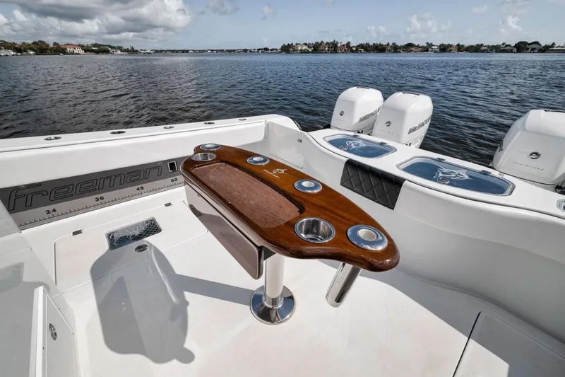 Slide: The Image of Freeman 42LR 2020 boat with wooden table and Mercury engines on a calm lake. - 35