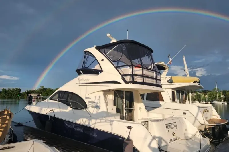 The Image of 2007 Sea Ray 44 Sedan Bridge yacht docked under a vibrant rainbow. - 0