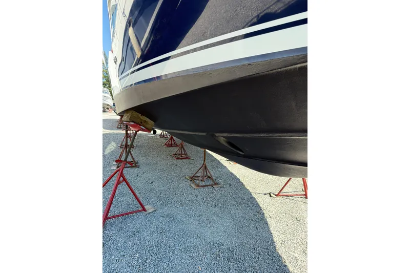 Slide: The Image of 2007 Sea Ray 44 Sedan Bridge boat hull on stands, gravel ground. - 11