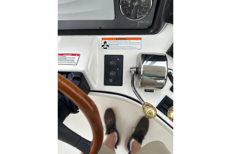 Slide: The Image of 2007 Sea Ray 44 Sedan Bridge helm controls with throttle and warning labels. - 15