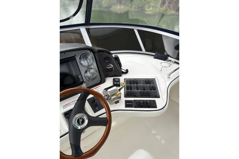 Slide: The Image of 2007 Sea Ray 44 Sedan Bridge helm with steering wheel and control panel. - 18
