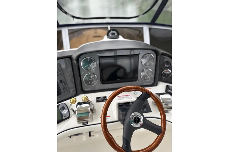 Slide: The Image of 2007 Sea Ray 44 Sedan Bridge helm with steering wheel and navigation controls. - 19