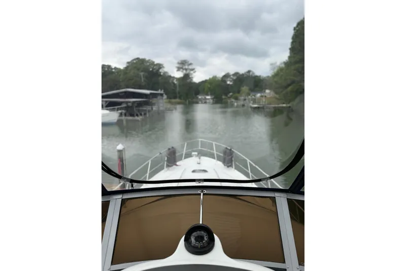 Slide: The Image of 2007 Sea Ray 44 Sedan Bridge navigating a serene, tree-lined waterway. - 21