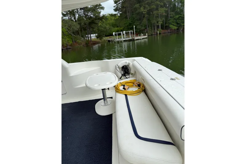 Slide: The Image of 2007 Sea Ray 44 Sedan Bridge deck with seating, table, and scenic water view. - 26