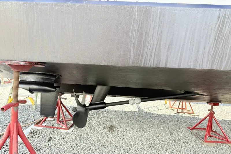 Slide: The Image of 2007 Sea Ray 44 Sedan Bridge hull and propeller on stands, gravel surface. - 30