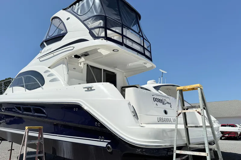 Slide: The Image of 2007 Sea Ray 44 Sedan Bridge yacht docked with ladder, clear blue sky background. - 4