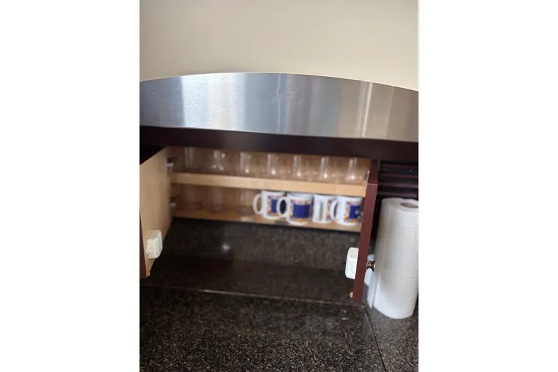 Slide: The Image of Cabinet interior on 2007 Sea Ray 44 Sedan Bridge, featuring mugs and paper towels. - 43
