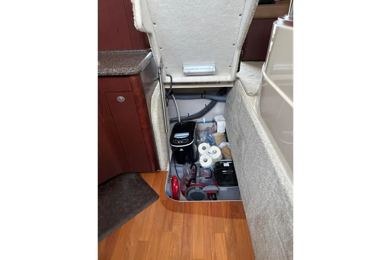 Slide: The Image of Storage compartment in 2007 Sea Ray 44 Sedan Bridge, featuring various supplies and equipment. - 48